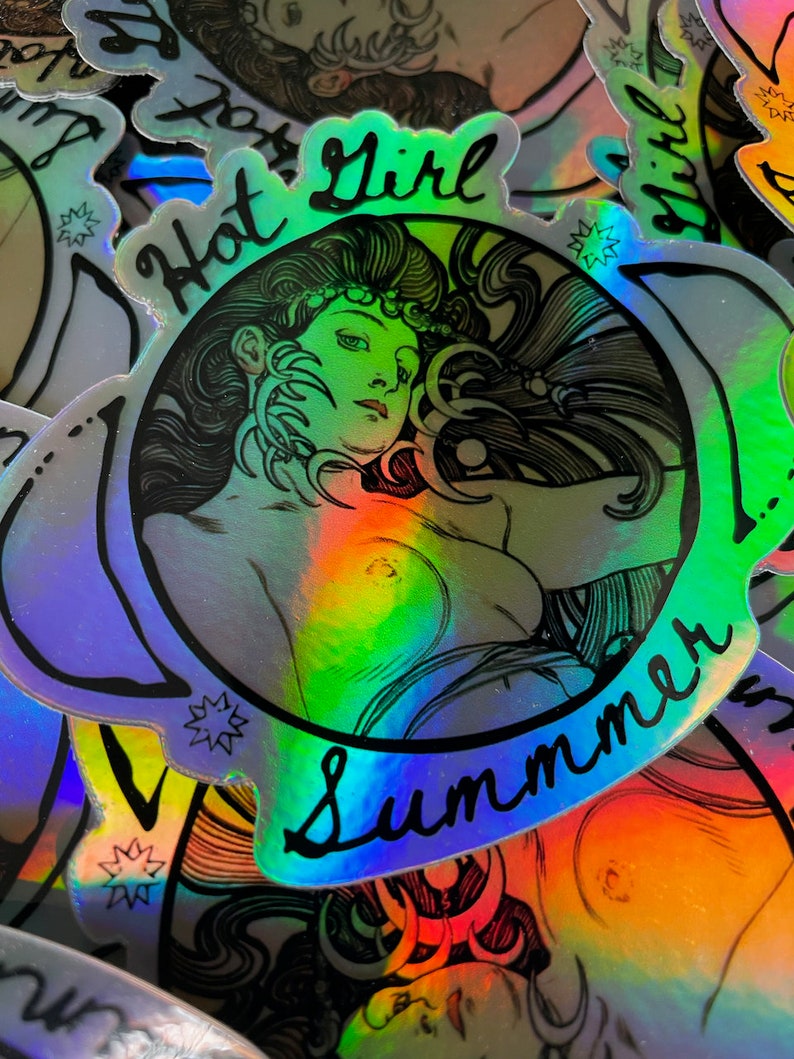 May include: Holographic sticker featuring a woman with long hair and the words "Hot Girl Summer" in a cursive font. The sticker has a rainbow sheen and a black outline. The image is a close-up of the sticker.