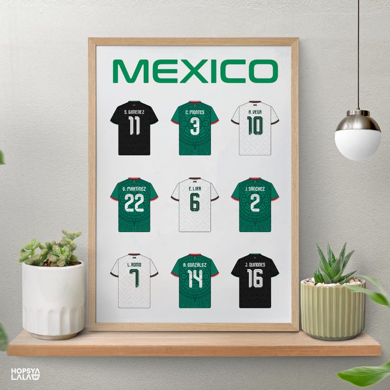 May include: A framed poster titled MEXICO featuring nine soccer jerseys arranged in a grid. The jerseys are black, green, and white, each displaying a player name and number on the back. The print is displayed in a light wood frame on a shelf.