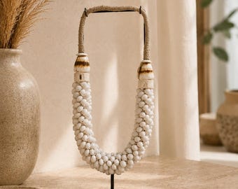 Boho necklace made of white seashells on a stand