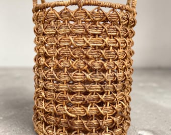 Tall, openwork basket made of plant material