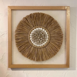 Rafia y conchas marinas sobre lienzo enmarcado