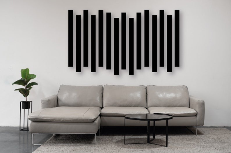 May include: A gray sectional sofa with a black coffee table in front of it. A black geometric wall art piece is hanging on the wall behind the sofa.