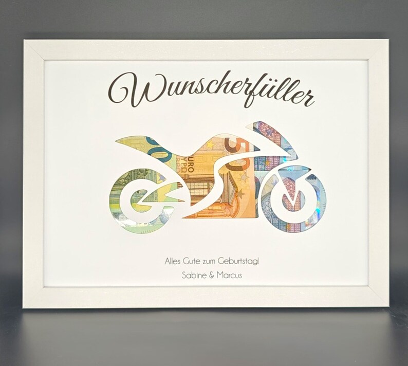 K&ouml;nnte beinhalten: Wei&szlig;er Rahmen mit einer Ausschnitt einer Motorrad. Das Motorrad ist mit Euro-Scheinen gef&uuml;llt. Der Text "Wunscherf&uuml;ller" befindet sich oben am Rahmen. Der Text "Alles Gute zum Geburtstag Sabine & Marcus" befindet sich unten am Rahmen.