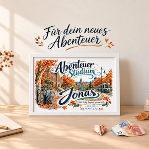Peut inclure: Une impression encadrée en blanc représentant une scène de ville en automne avec un vélo, un tramway et des arbres aux feuilles orange. Le texte indique "Für dein neues Abenteuer", "Abenteuer Studium", "Jonas", "Dein Weg beginnt genau hier", "01.10.2026" et "Von Mama & Papa".