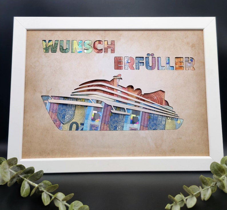 Puede incluir: Una imagen enmarcada en blanco con un fondo marr&oacute;n. La imagen presenta un crucero hecho de billetes de euro con las palabras "Wunsch Erf&uuml;ller" escritas sobre el barco.