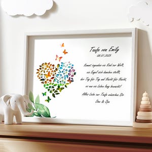 May include: A white framed print with a colorful heart made of butterflies and flowers. The text reads "Taufe von Emily 08.07.2025" and a poem about a child's baptism.