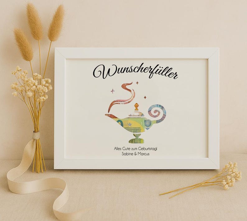 May include: A white frame with a white mat and a picture of a genie lamp made of money. The text "Wunschersch&uuml;ller" is at the top of the picture. The text "Alles Gute zum Geburtstag Sabine & Marcus" is at the bottom of the picture.