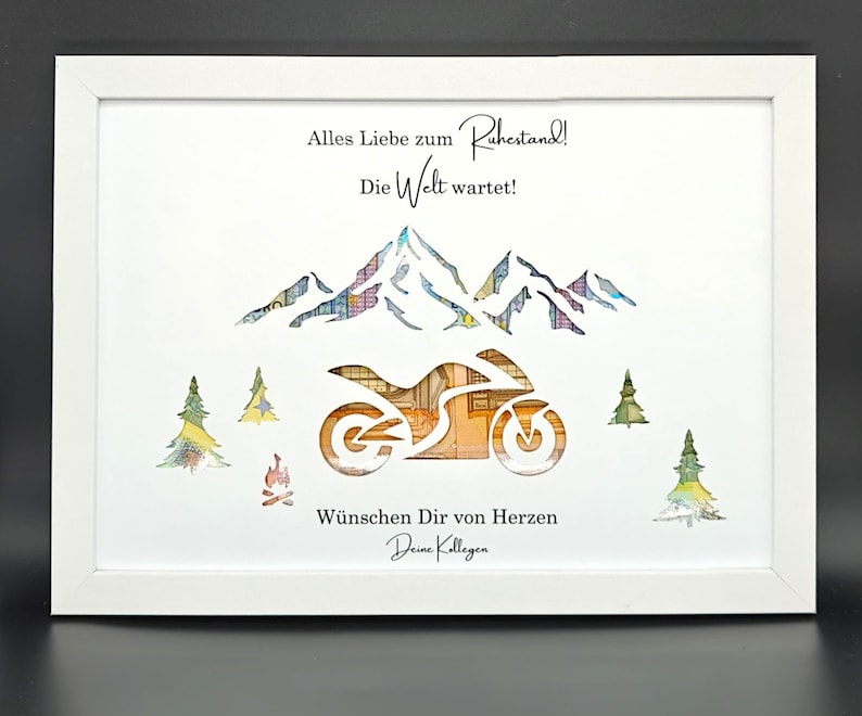 May include: A white framed picture with a white background. The picture features a cut-out design of a motorcycle, mountains, and trees. The motorcycle is made of money. The text in the picture reads "Alles Liebe zum Ruhestand! Die Welt wartet! W&uuml;nschen Dir von Herzen Deine Kollegen".