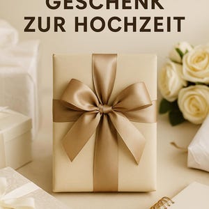 May include: A beige gift box tied with a gold satin ribbon and bow. The text "DAS PERFEKTE GESCHENK ZUR HOCHZEIT" is at the top. Other gift boxes and a bouquet of white roses are in the background. A spiral notebook is on the right.