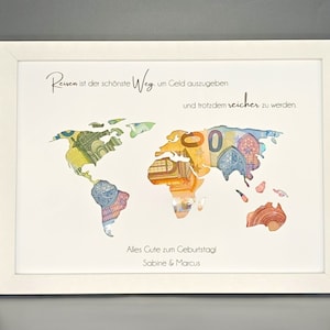 May include: A white framed picture with a world map made of euro bills. The text reads "Reisen ist der sch&ouml;nste Weg um Geld auszugeben und trotzdem reicher zu werden." and "Alles Gute zum Geburtstag! Sabine & Marcus".