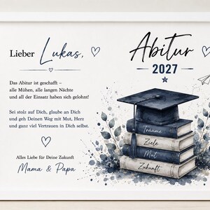 Pu&ograve; includere: Una stampa bianca incorniciata con il testo 'Lieber Lukas, Abitur 2027' e un messaggio di congratulazioni in tedesco. Il design include un'illustrazione ad acquerello di un tocco di laurea appoggiato su quattro libri etichettati Tr&auml;ume, Ziele, Mut, Zukunft.