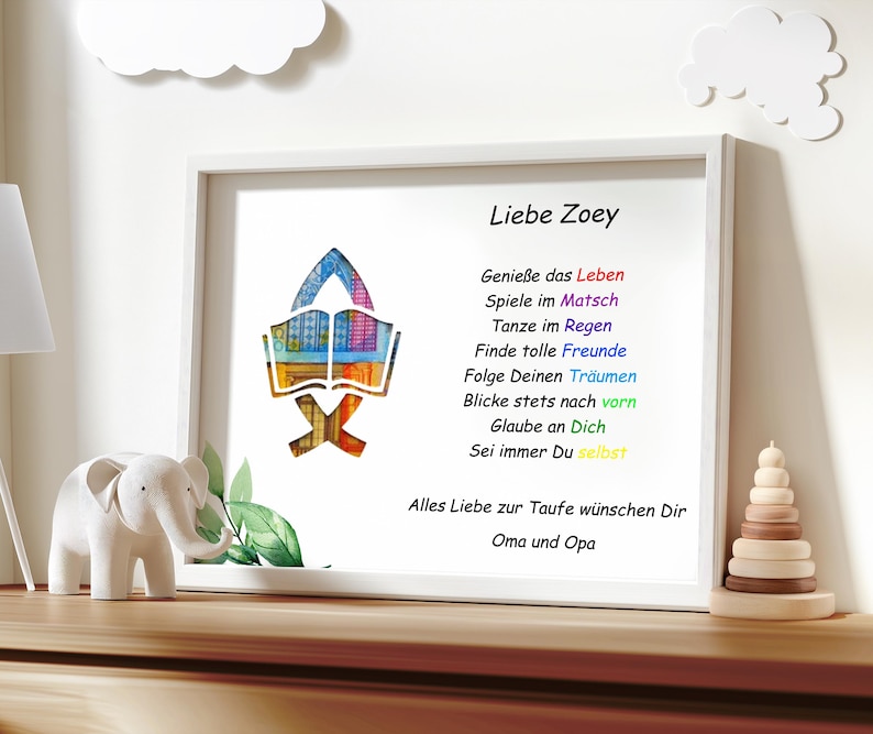 Puede incluir: Una impresi&oacute;n enmarcada en blanco con una ilustraci&oacute;n colorida de un libro abierto. El texto dice "Liebe Zoey" e incluye un poema sobre disfrutar la vida, seguir los sue&ntilde;os y creer en ti mismo. La impresi&oacute;n est&aacute; firmada "Alles Liebe zur Taufe w&uuml;nschen Dir Oma und Opa".