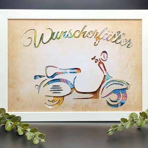 May include: A white frame with a beige background featuring a cutout of a scooter made from colorful paper money. The text "Wunsch erf&uuml;ller" is written in a decorative font above the scooter.
