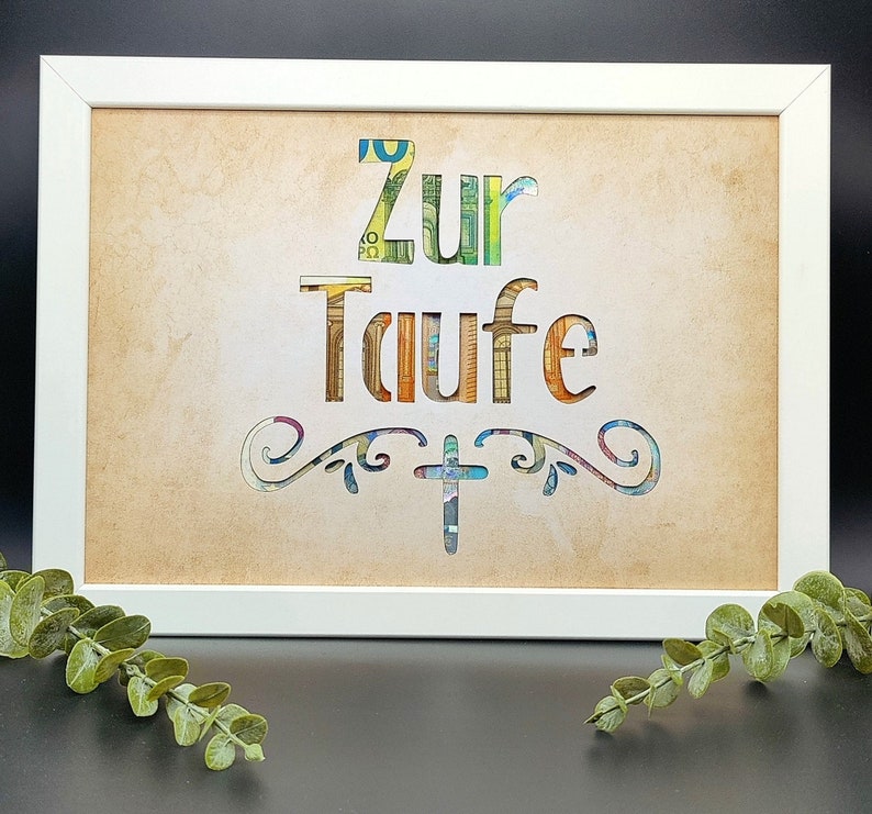 May include: A white framed picture with a brown background. The words "Zur Taufe" are cut out of the background and filled with colorful paper. A cross is cut out below the words.