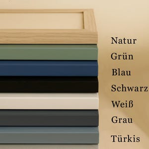 Peut inclure: Une pile de cadres photo de diff&eacute;rentes couleurs : bois naturel, vert, bleu, noir, blanc, gris, turquoise et argent. Le texte "Farbauswahl Bilderrahmen" est en haut.