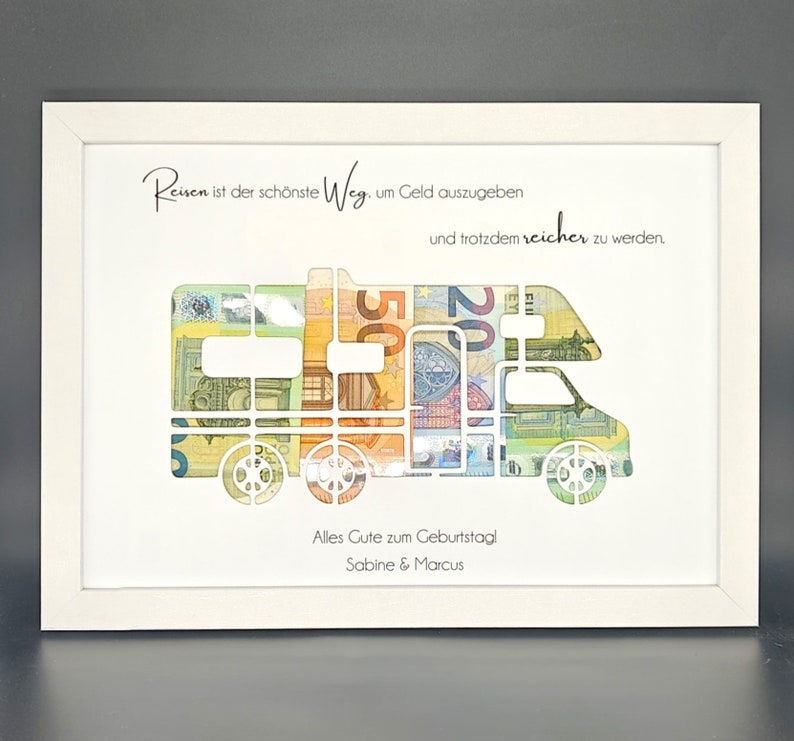 May include: A white framed print with a camper van silhouette made of euro bills. The text reads "Reisen ist der sch&ouml;nste Weg um Geld auszugeben und trotzdem reicher zu werden." and "Alles Gute zum Geburtstag! Sabine & Marcus".