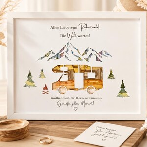 May include: A white framed print featuring a cutout camper van silhouette filled with folded currency, surrounded by watercolor illustrations of mountains, pine trees, and a campfire, with German text including Alles Liebe zum Ruhestand.