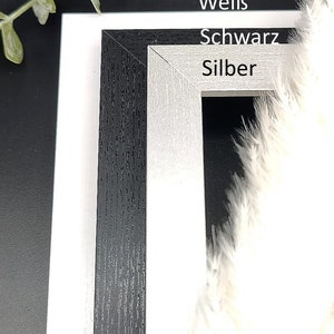Puede incluir: Dos marcos de fotos, uno negro y otro plateado, con las palabras "Premium", "Wei&szlig;", "Schwarz" y "Silber" impresas en la parte delantera.