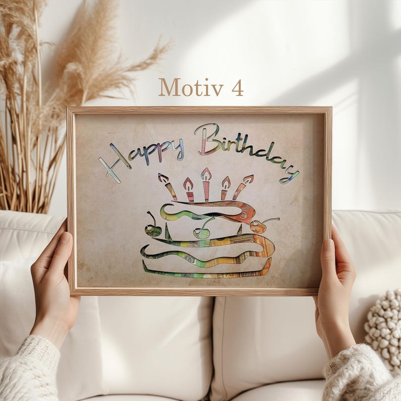 May include: A framed print with a beige background featuring the words "Happy Birthday" in a colorful, layered font. A colorful cake with candles is depicted below the text.