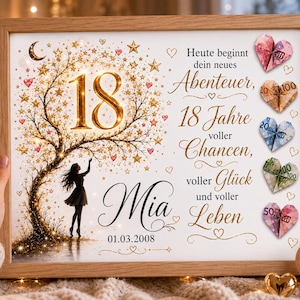 May include: A framed print featuring a gold tree with stars, the number 18, and the name Mia with the date 01.03.2008. The text reads: Heute beginnt dein neues Abenteuer, 18 Jahre voller Chancen, voller Gl&uuml;ck und voller Leben. Five origami hearts made from banknotes are attached to the right side.