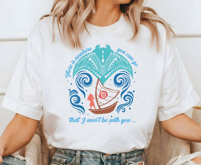 Puede incluir: Camiseta blanca con un dise&ntilde;o gr&aacute;fico azul y turquesa que representa un barco estilizado con una persona a bordo. El texto "There is nowhere you can go that I won't be with you..." est&aacute; impreso en la camiseta.