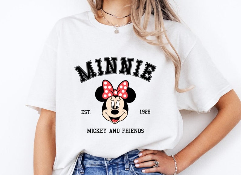 May include: White t-shirt with a black and red Minnie Mouse graphic. The text "MINNIE" is above the graphic, and "EST. 1928" and "MICKEY AND FRIENDS" are below the graphic.