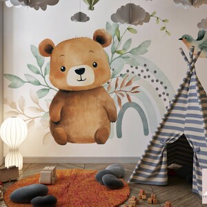 May include: A brown teddy bear with a watercolor rainbow and green leaves on a white wall. A blue and white striped teepee tent is in the foreground.