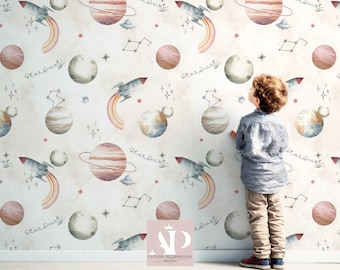 Könnte beinhalten: Weltraum-Tapete mit Aquarell-Illustrationen von Planeten, Raketen und dem Wort "Stardust". Das Design umfasst Planeten mit Ringen, Raketen mit Regenbogen-Spuren und Sternbilder. Ein Kind betrachtet die Tapete.