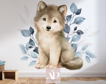 Könnte beinhalten: Aquarell-Illustration eines niedlichen Wolfsjungen mit weichem, flauschigem Aussehen. Der Wolf sitzt, umgeben von blauen und grauen Blättern. Das Bild hat eine skurrile, sanfte Ästhetik, passend für die Kinderzimmerdekoration.