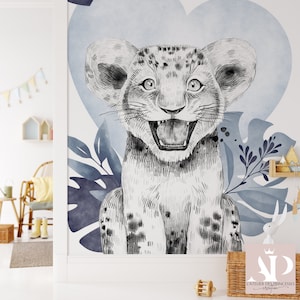 May include: A black and white illustration of a lion cub with its mouth open, set against a blue watercolor background with leafy foliage.