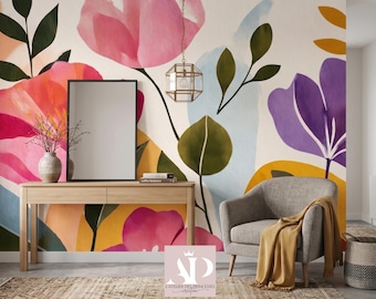 Könnte beinhalten: Ein Raum mit einem Blumengemälde mit großen rosa, lila und gelben Blumen. Ein Holztisch mit einer Vase und einem schwarzen Spiegel. Ein grauer Sessel mit einer gelben Decke steht in der Nähe eines geflochtenen Korbes.