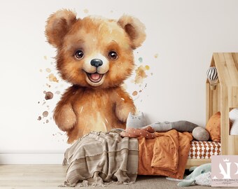 Könnte beinhalten: Aquarell-Illustration eines lächelnden braunen Teddybären mit fröhlichem Ausdruck. Der Bär hat hellbraunes Fell und ist von Aquarellfarbspritzern umgeben. Das Bild ist ein Wandtattoo, ideal für ein Kinderzimmer.
