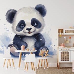 May include: A watercolor illustration of a cute panda bear sitting on a white background. The panda is wearing a black and white fur coat and has a big smile on its face. The illustration is surrounded by blue watercolor splatters.