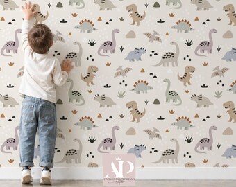 Könnte beinhalten: Ein Kind steht vor einer Wand, die mit einem sich wiederholenden Muster von Cartoon-Dinosauriern in Braun-, Grün-, Lila- und Blautönen auf cremefarbenem Hintergrund bedeckt ist. Zu den Dinosauriern gehören T-Rex, Stegosaurus und Brontosaurus. Schwarze und braune geometrische Formen und Pflanzen sind ebenfalls verstreut.