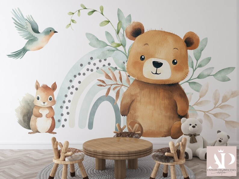 May include: A watercolor illustration of a brown bear, a squirrel, and a bluebird with a rainbow in the background. The illustration is on a white wall with two wooden chairs and a wooden table in front of it.