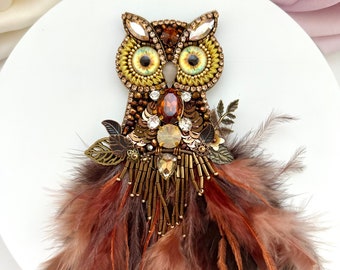 Handmade Designer brooch “Magic Owl” in golden brown colors. Large beaded rhinestones pin brooch with feathers. Unique bird designs brooch.