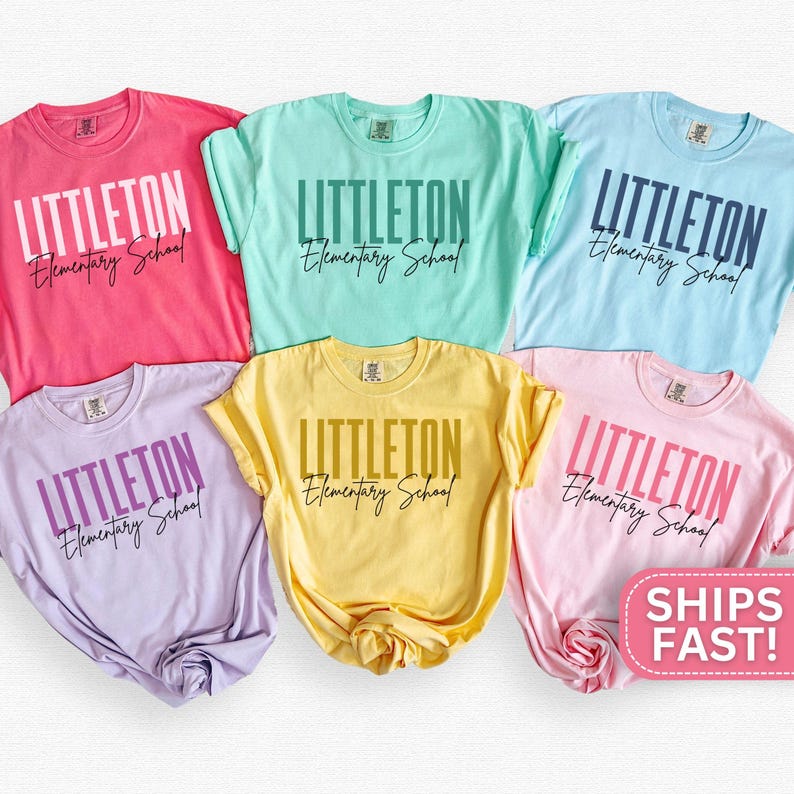 May include: Six pastel-coloured t-shirts, including pink, mint green, light blue, lilac, yellow, and pale pink. Each shirt displays the text "LITTLETON Elementary School" in a bold font. The shirts are arranged in a visually appealing display.