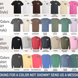May include: A variety of t-shirts and sweatshirts in various colors, including black, white, and navy. The shirts and sweatshirts have the word "DAD" printed on them. The image also includes the text "LOOKING FOR A COLOR NOT SHOWN? SEND US A MESSAGE!"