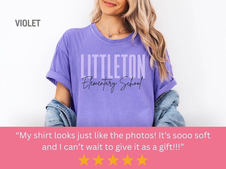 May include: A violet t-shirt featuring the text "LITTLETON Elementary School". The shirt has rolled-up sleeves and is worn by a person. The word "VIOLET" is in the top left corner. The shirt is a shade of purple.