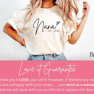 May include: A white t-shirt with the text "Nana EST. 2025" in black script font. The shirt is shown on a model with a light background. The text "Love it Guarantee" is shown in pink at the bottom of the image. The text "IVORY" is shown in black at the bottom right of the image.