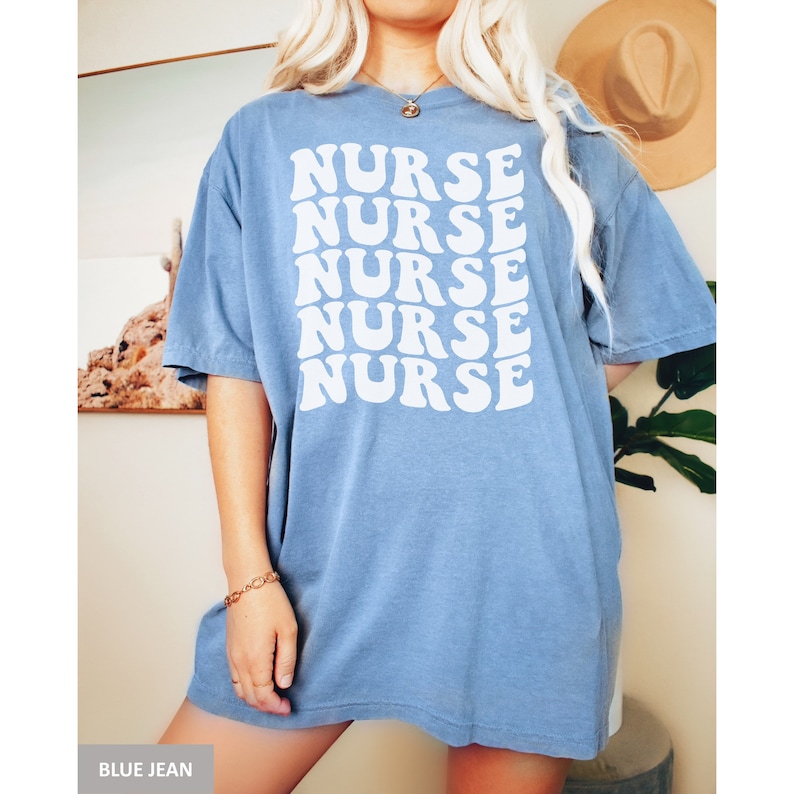 May include: A blue jean t-shirt with the word "NURSE" repeated five times in a retro, white font.