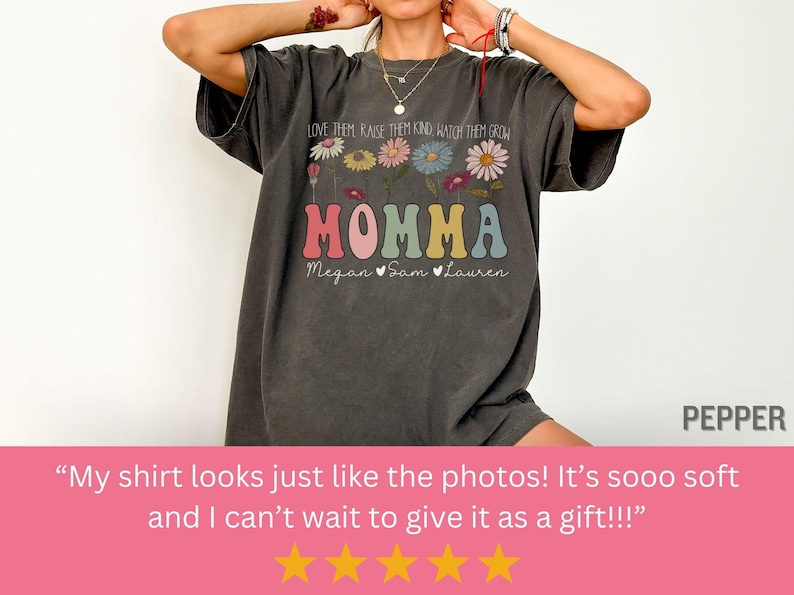 May include: A dark gray t-shirt with a floral design and the text "LOVE THEM RAISE THEM KIND WATCH THEM GROW MOMMA Megan Sam Lauren".