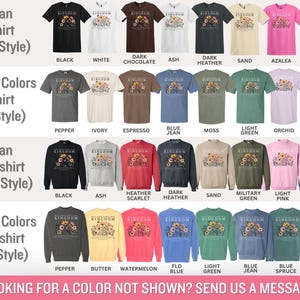 K&ouml;nnte beinhalten: Eine Auswahl an T-Shirts und Sweatshirts in verschiedenen Farben, darunter Schwarz, Wei&szlig; und Marineblau. Die Shirts zeigen den Text "KINGDOM" mit einem floralen Design. Stile umfassen Gildan und Comfort Colors.