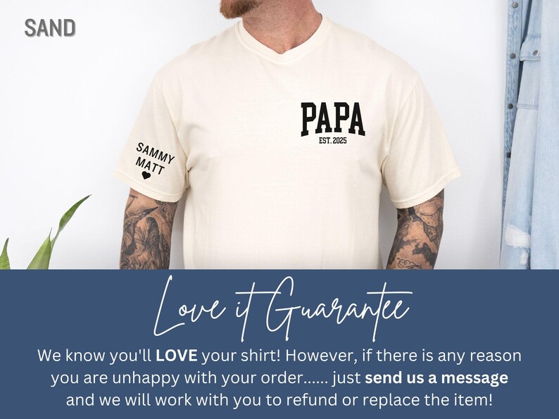 Op de afbeelding: Zandkleurig T-shirt met het woord "PAPA" in vette zwarte letters en "EST. 2025" eronder. Op de linkermouw staan de namen "SAMMY" en "MATT" met een hartje. Het shirt maakt deel uit van een kledingcollectie.