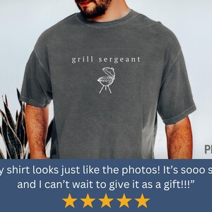 Op de afbeelding: Donkergrijs t-shirt met de tekst "grill sergeant" en een witte afbeelding van een grill. Een casual shirt voor liefhebbers van barbecue&euml;n.