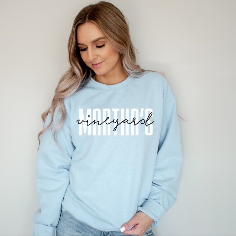K&ouml;nnte beinhalten: Ein hellblauer Pullover mit dem Aufdruck "Martha's Vineyard" in Wei&szlig; auf der Vorderseite.