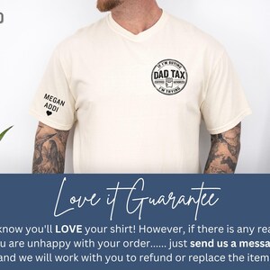 以下が含まれることがあります： 砂色のTシャツ。円形のデザインに「Dad Tax」の文字。左袖には「Megan Addi」とハートの文字。普段使いにぴったりのカジュアルTシャツです。