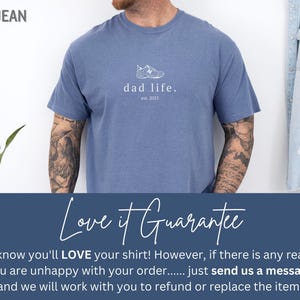 May include: A blue t-shirt with a white graphic of a sneaker and the text "dad life. est. 2023".