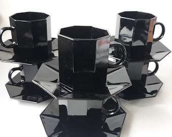 May include: A set of three black octagonal teacups and saucers. The cups and saucers are stacked on top of each other.