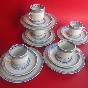 May include: Set of four white teacups and saucers with blue and white floral designs. The cups and saucers have a traditional Chinese pattern.